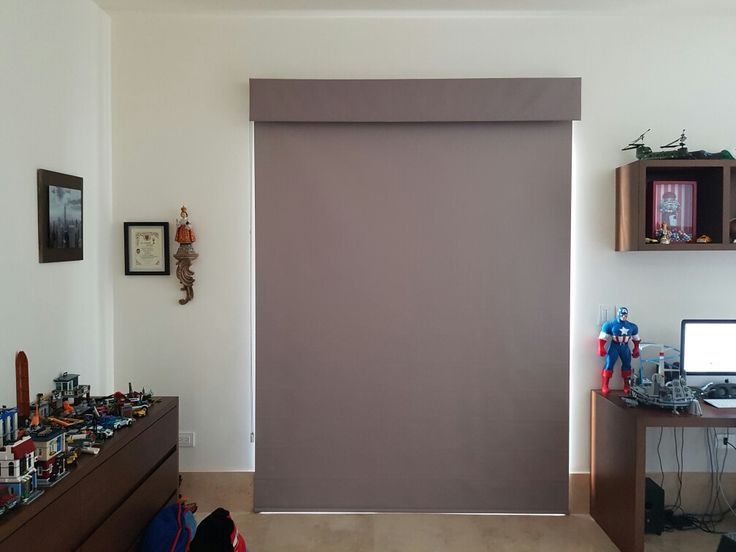 Una habitación con una ventana grande y un escritorio con una computadora encima.