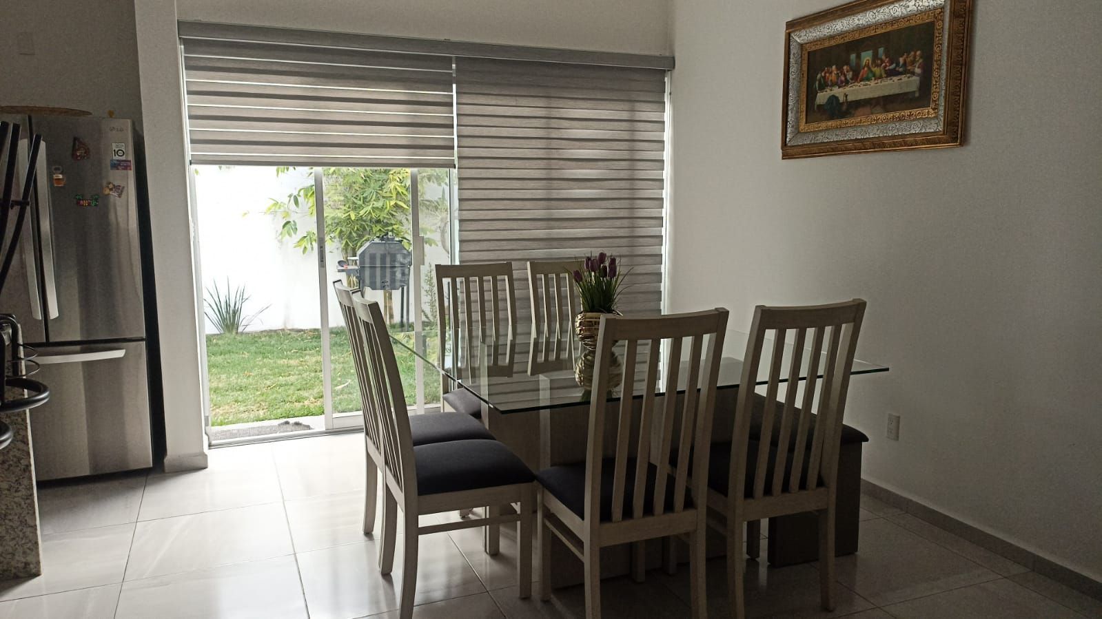 Un comedor con mesa y sillas y una puerta corrediza de vidrio.