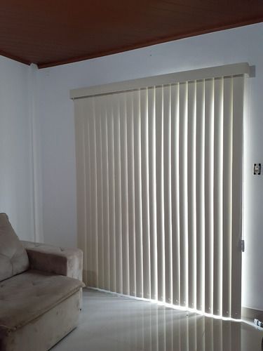 Una sala de estar con un sofá y persianas en la ventana.