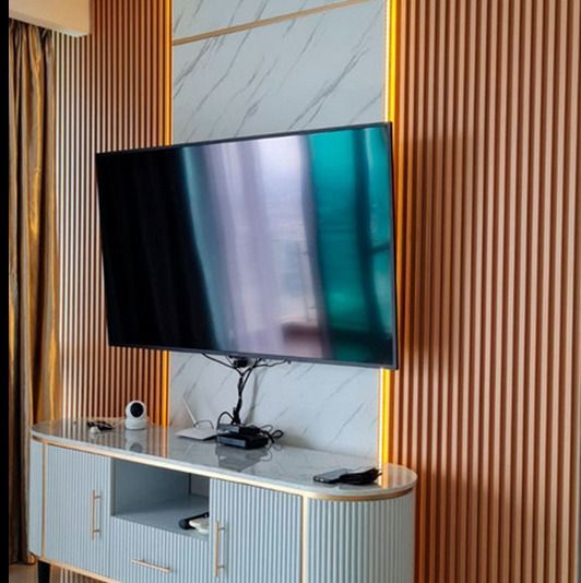 Un televisor de pantalla plana está sobre un centro de entretenimiento de madera en una sala de estar.