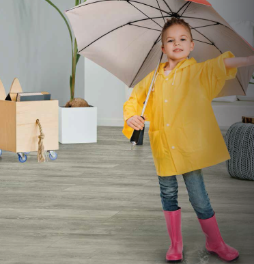 Una niña con un impermeable amarillo sostiene un paraguas.