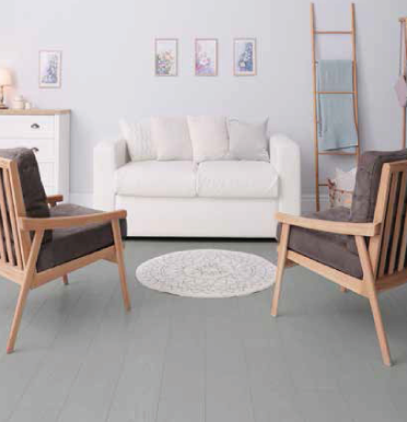 Una sala de estar con un sofá blanco y dos sillas.