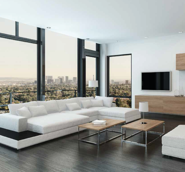 Una sala de estar con un gran sofá seccional y un televisor de pantalla plana.