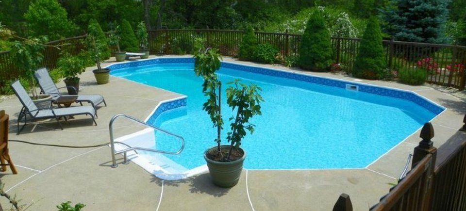 A large swimming pool surrounded by chairs and trees