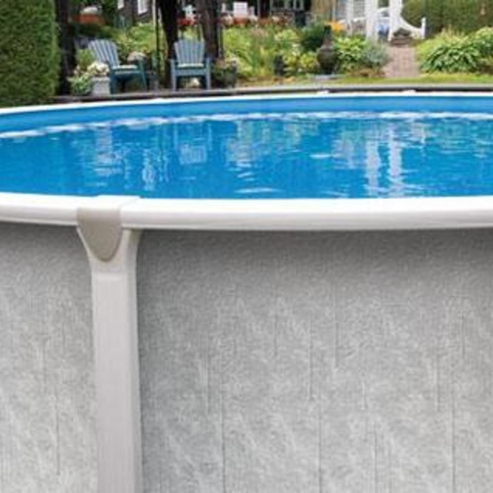 A large swimming pool filled with blue water in a backyard.