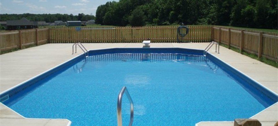 A large swimming pool with a wooden fence around it