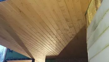 Wood plank ceiling on a porch. Diagonal lines and natural wood color are visible.