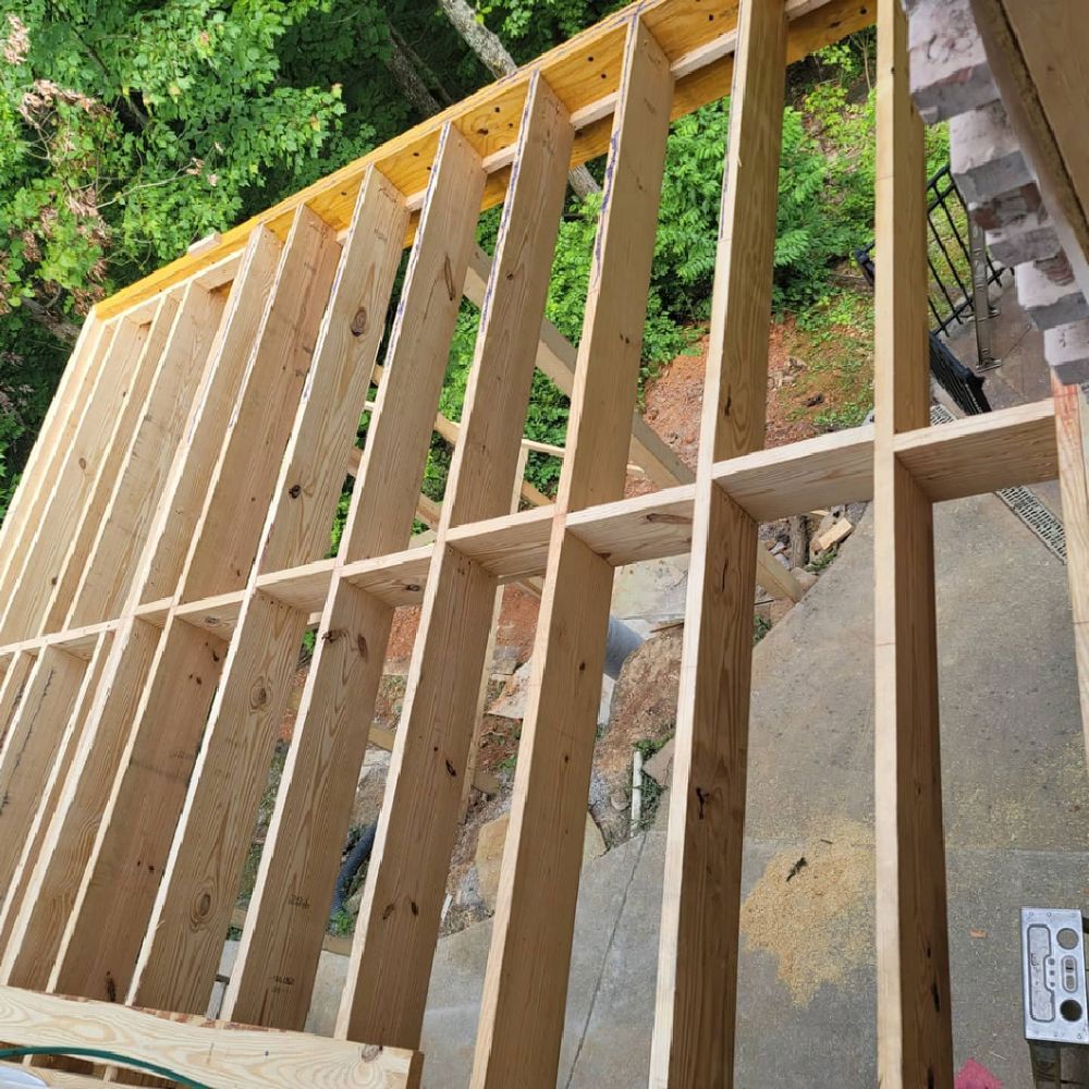 Wooden wall frame under construction outdoors.