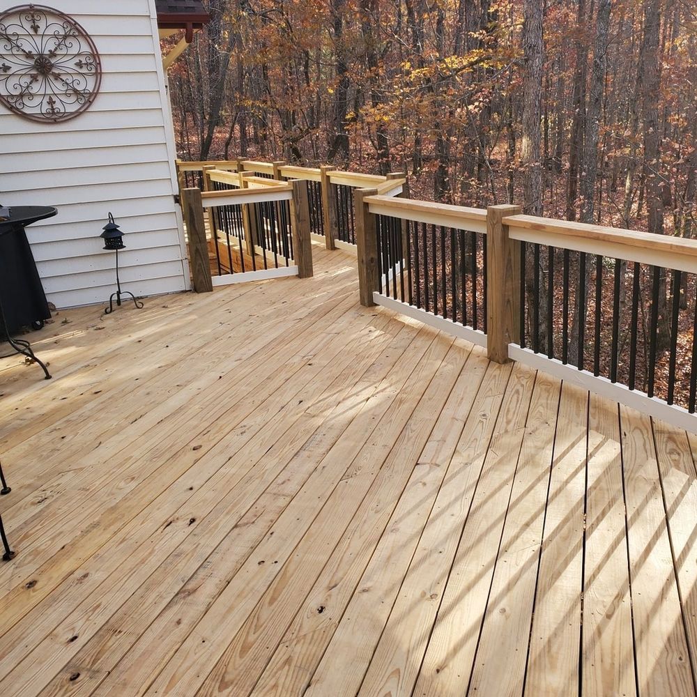 Wooden deck with railing, overlooking a forest.