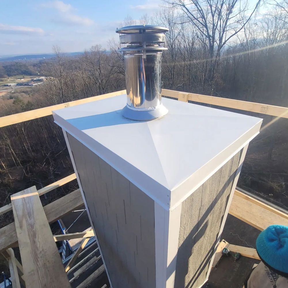 Chimney on rooftop with stainless steel cap, construction site, neutral colors.