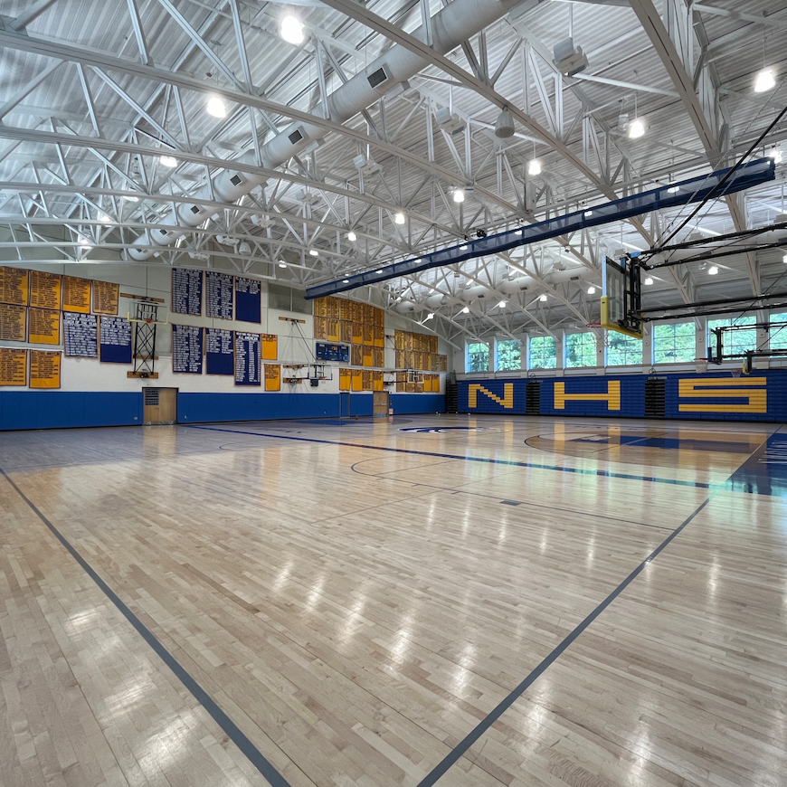 A basketball court with nhs written on the wall