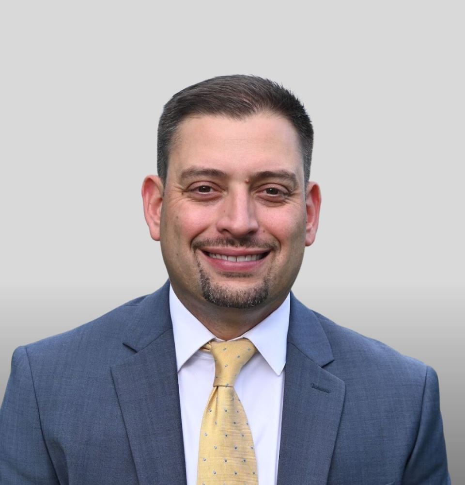 A man in a suit and tie is smiling for the camera.