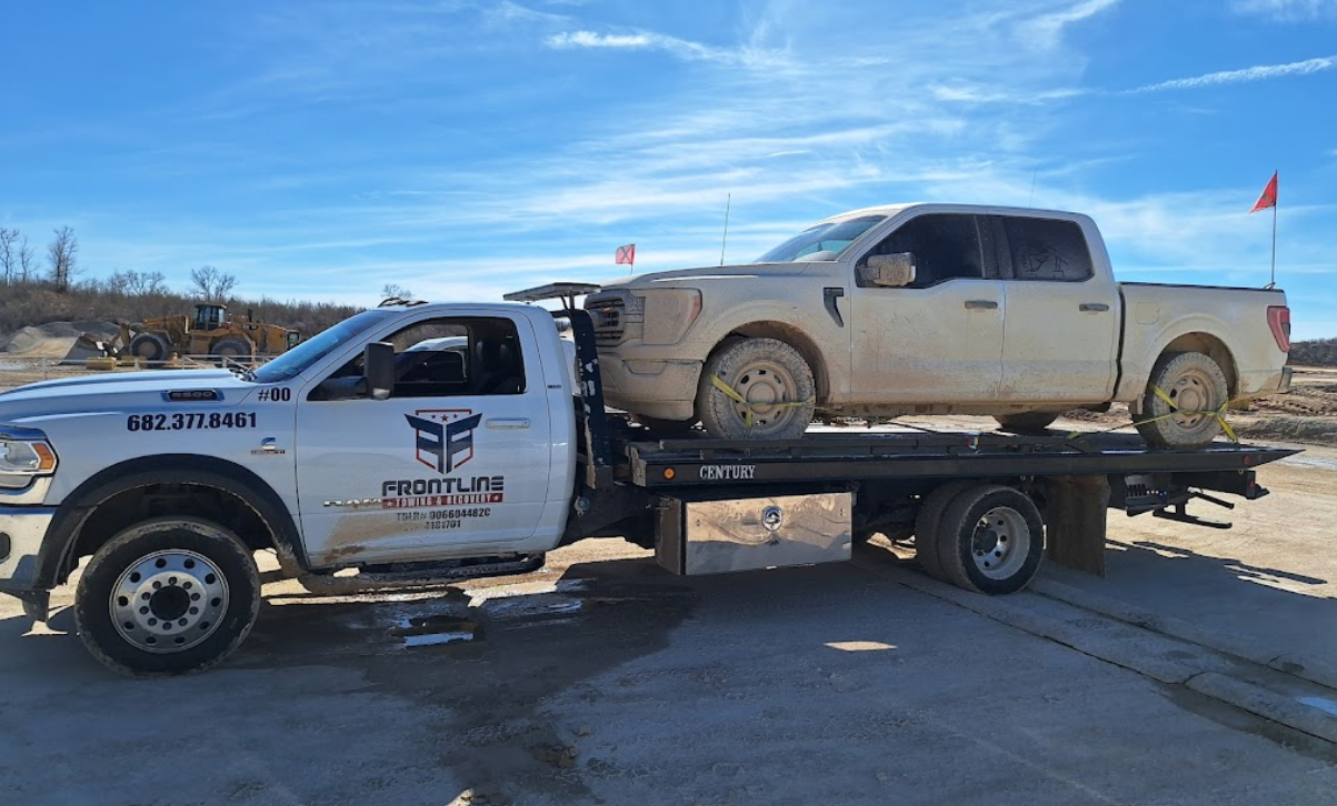 Two trucks are sitting on top of a tow truck.