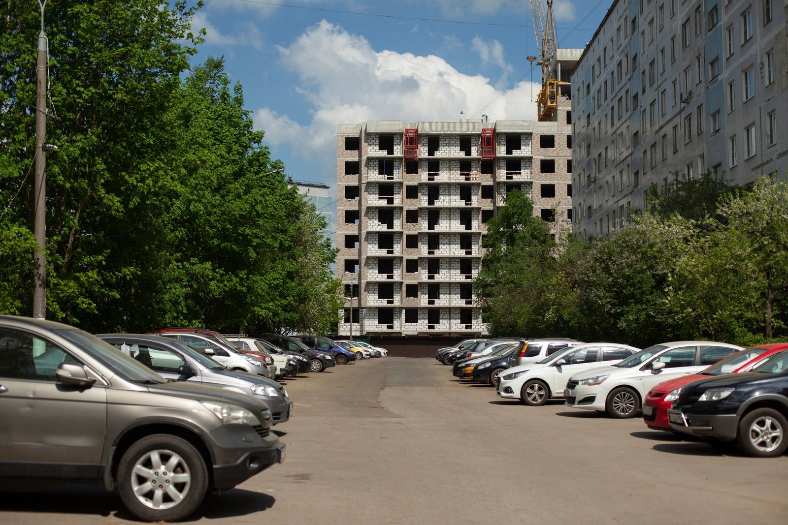 A carport with a wooden fence in front of a building.