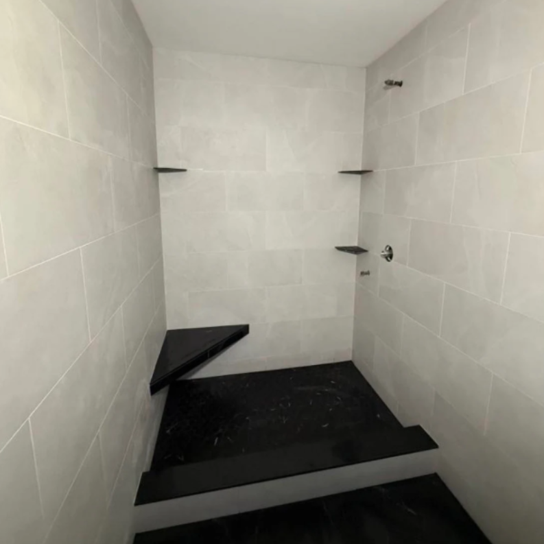 A modern fireplace built into a white stone wall, with a recessed space for a TV and soundbar.