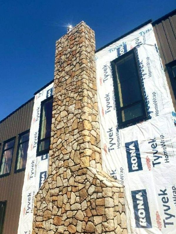 A large stone chimney on the side of a building