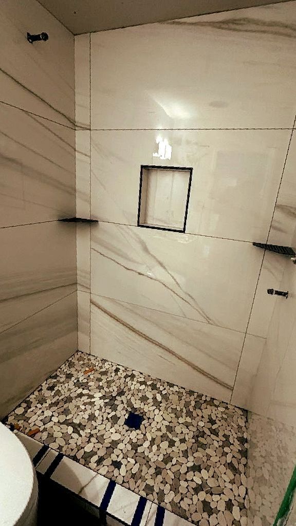 A bathroom with a walk in shower and a toilet.