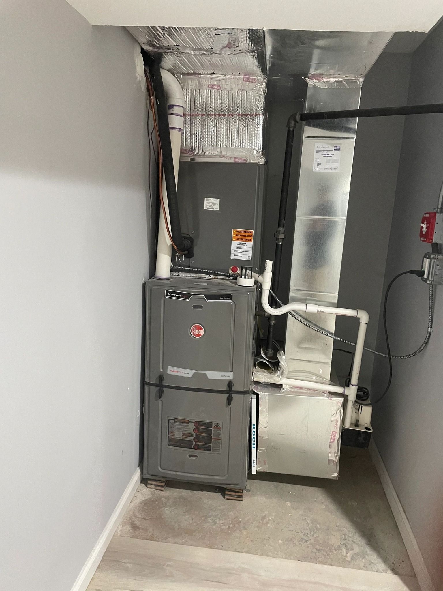 A room with a furnace and air conditioner in it.