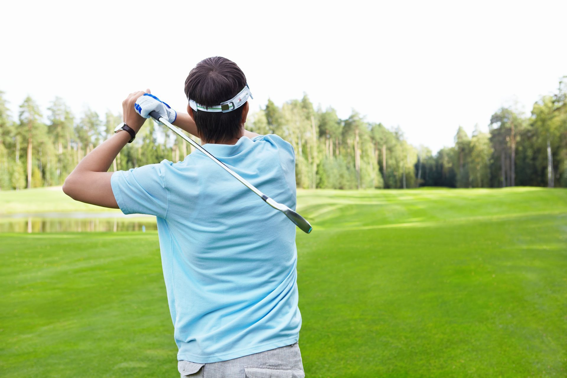 a man is swinging a golf club on a golf course .