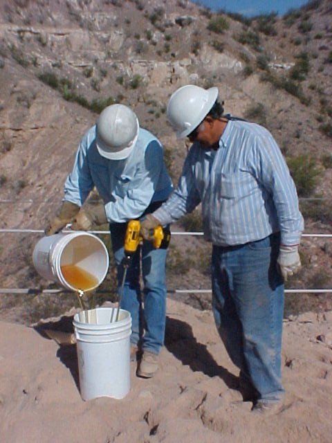 Two men mixing Secure Set components with buckets and power stirring tool