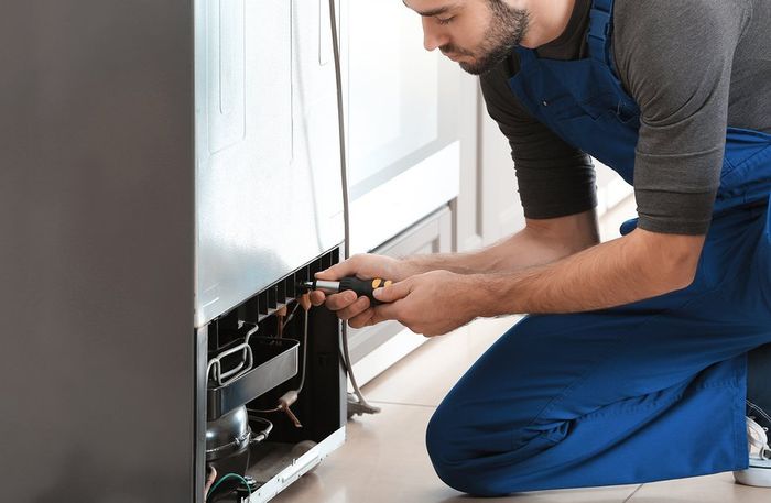 male worker repairing the refrigerator