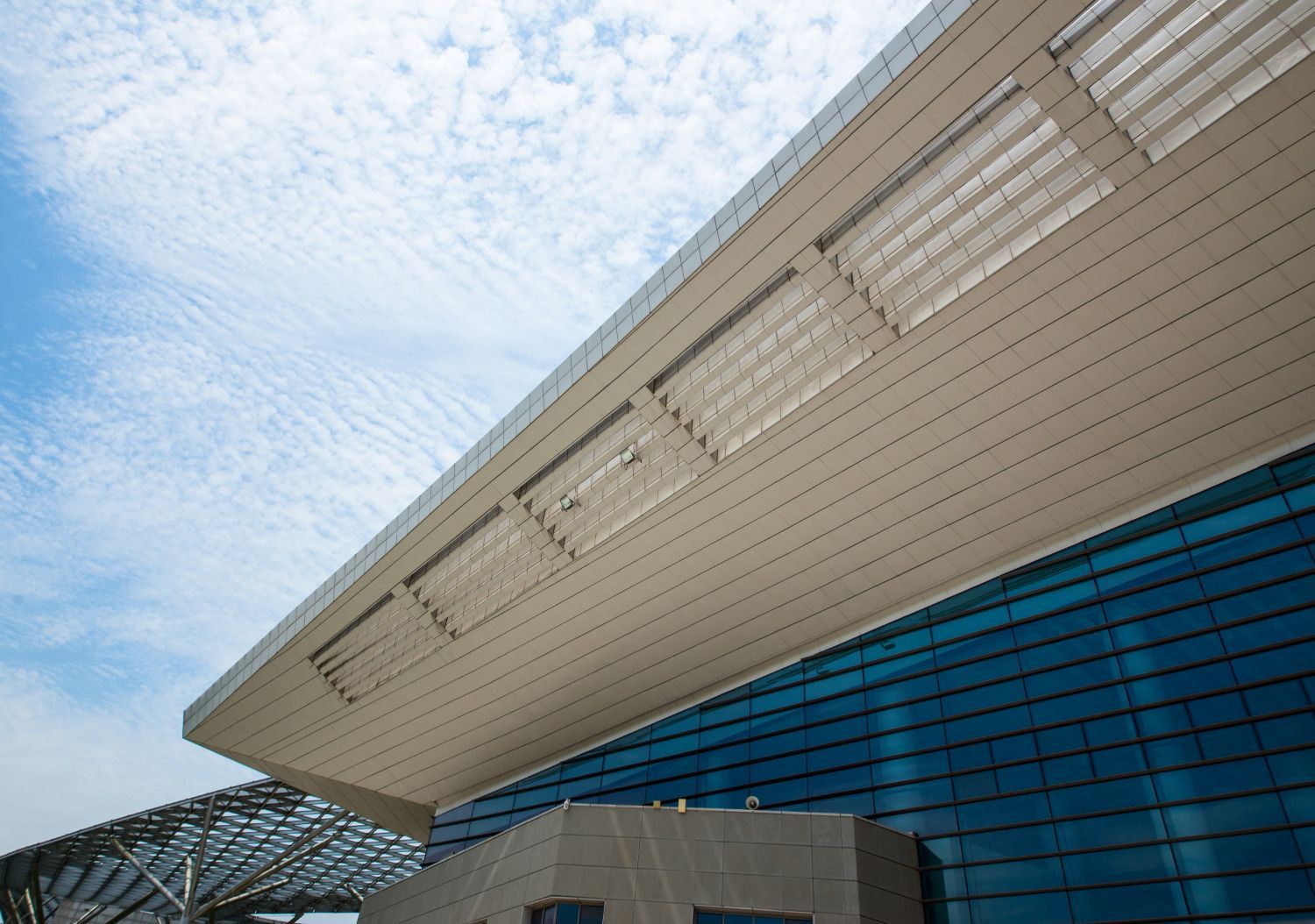 A large building with a lot of windows and a blue sky in the background.