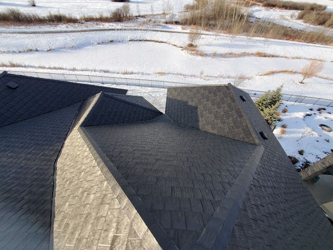 An aerial view of a roof with a snowy field in the background