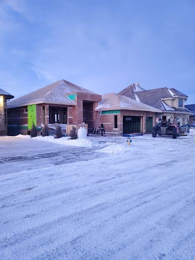 A row of houses under construction in a snowy neighborhood.