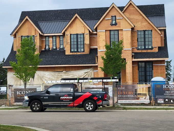 A truck is parked in front of a house under construction