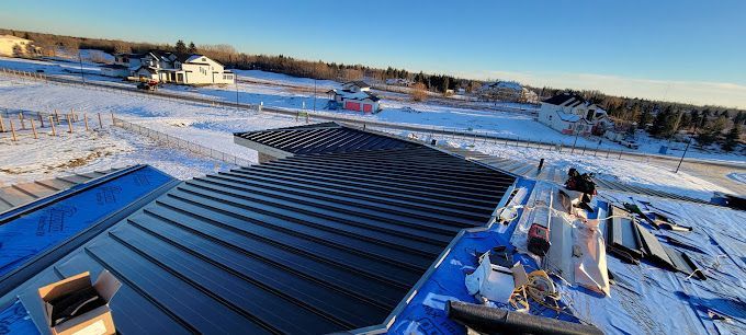 The roof of a house is being built in the snow.
