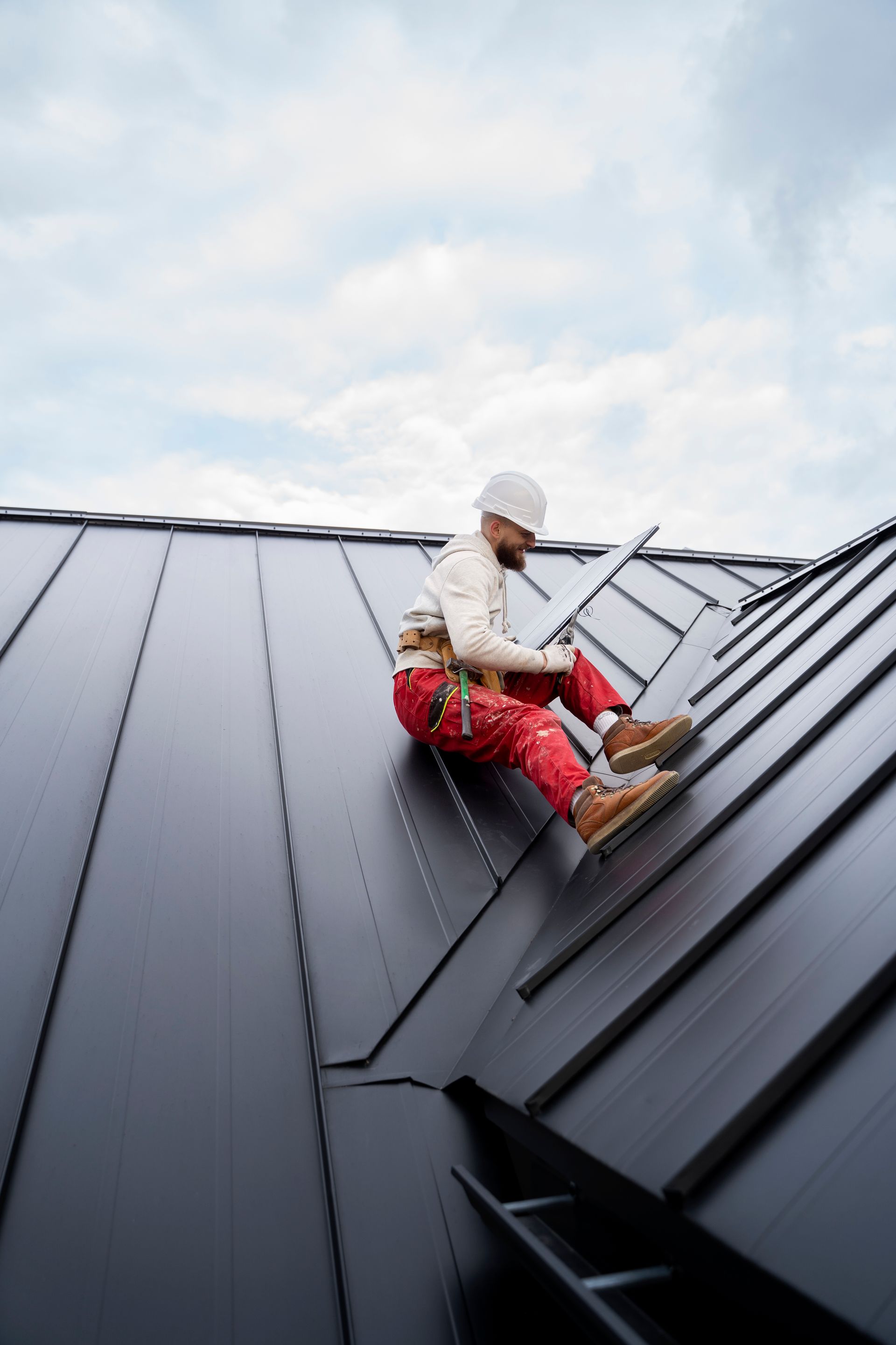 A man is sitting on the roof of a building.