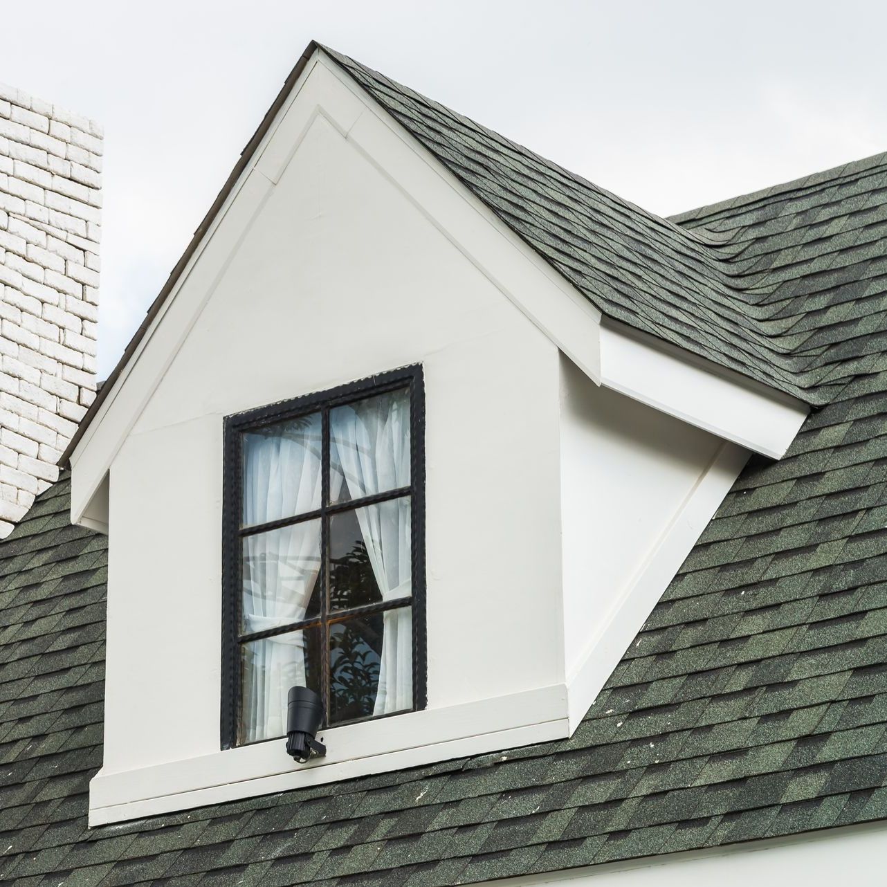 A white house with a window on the roof