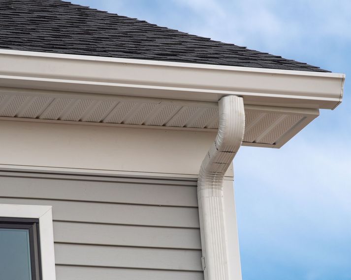 A house with a gutter on the side of it and a window.