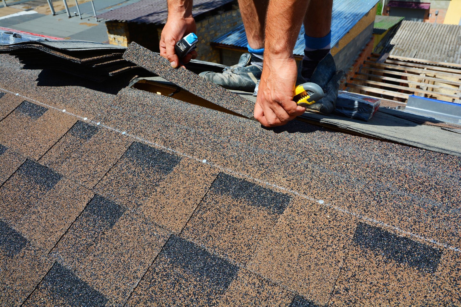 A man is installing shingles on a roof.