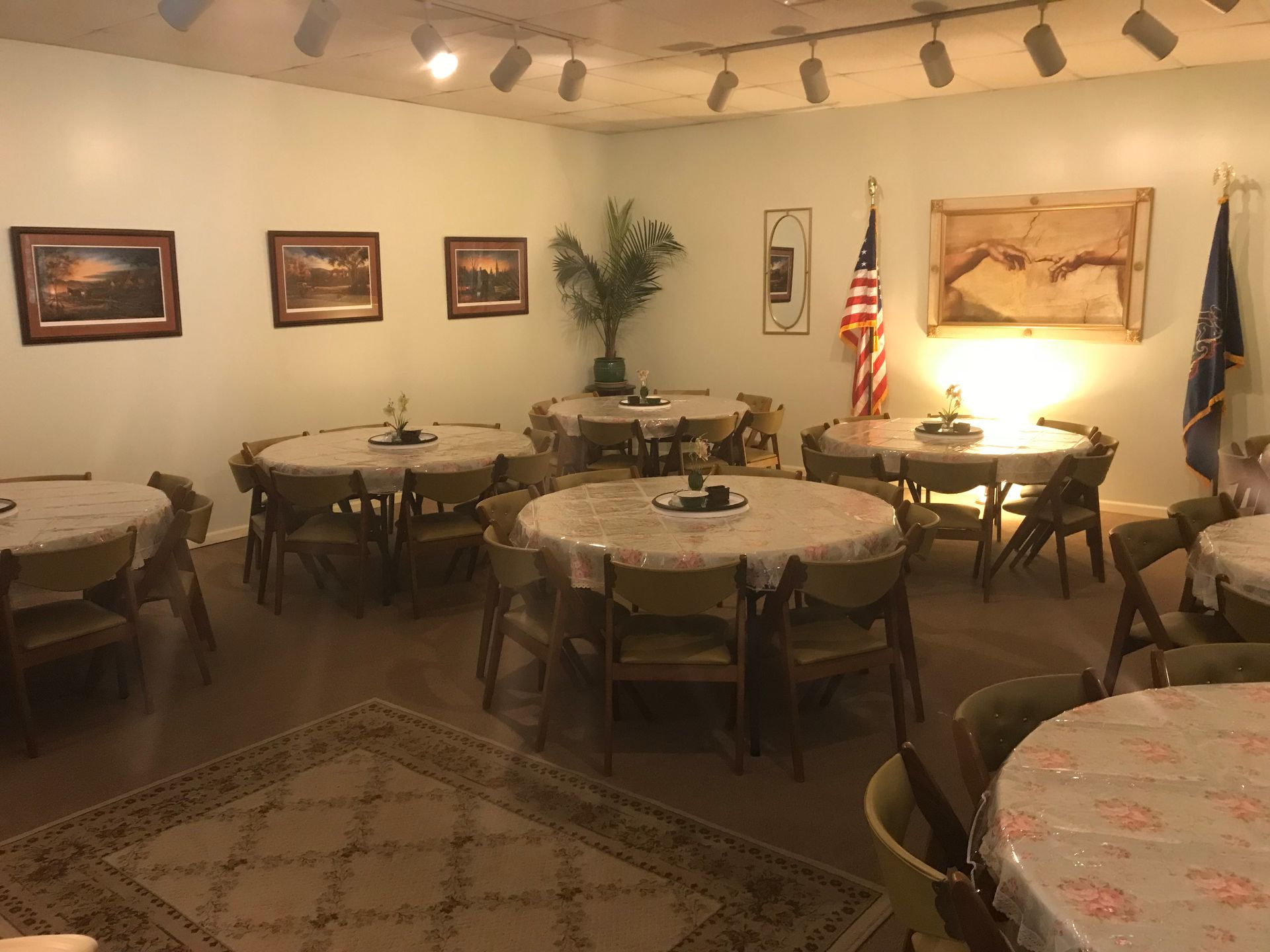 A room filled with tables and chairs with flags on the wall.