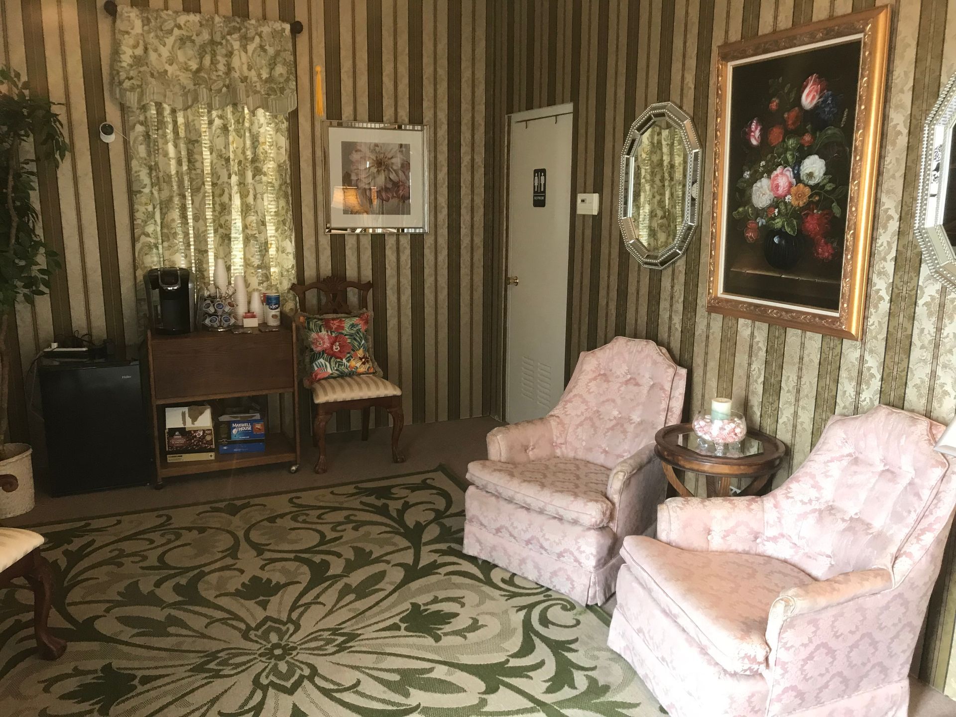 A living room with two pink chairs and a rug