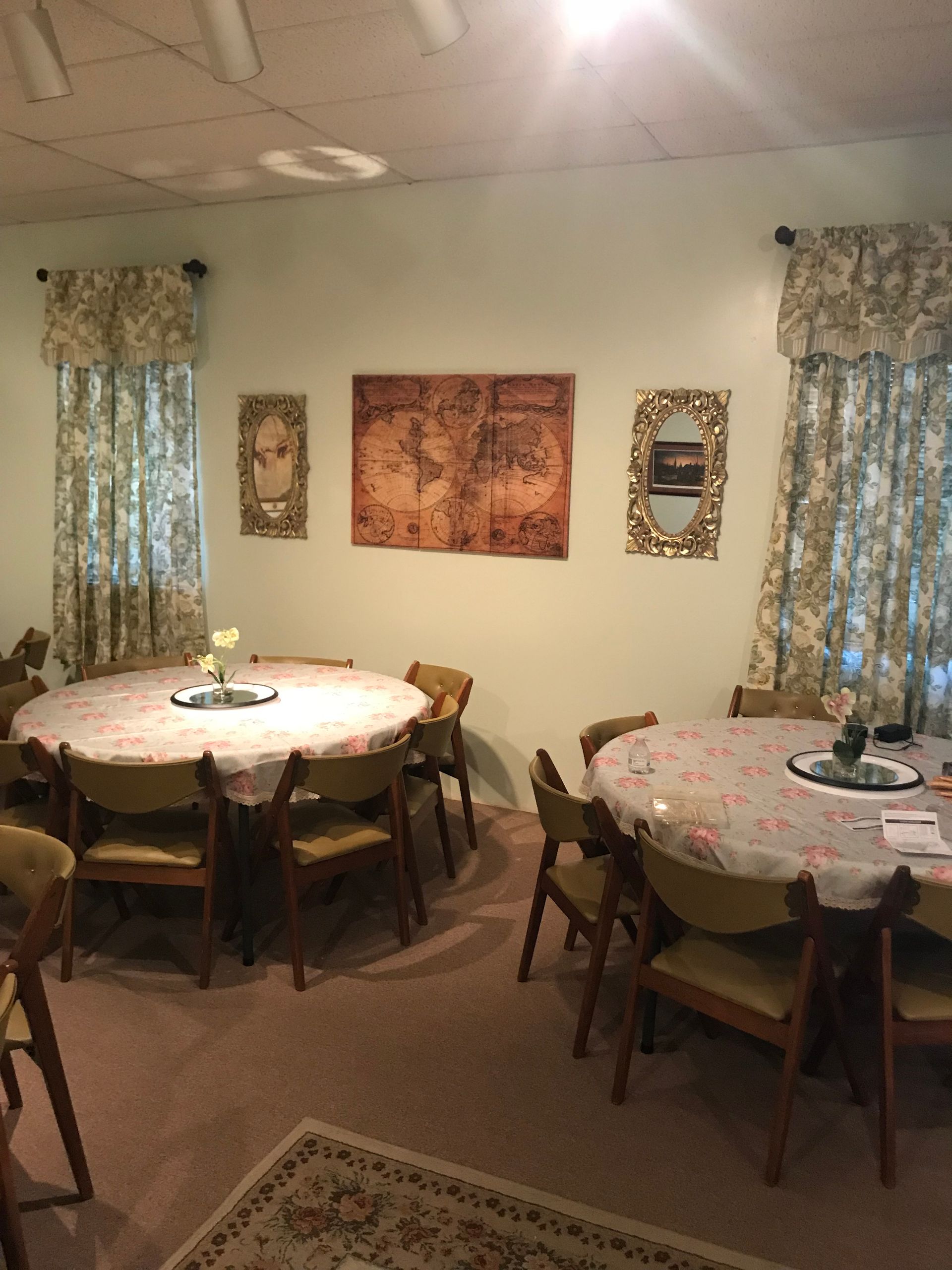 A room with tables and chairs and a map on the wall