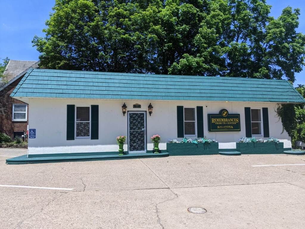 A white building with a green roof and a sign that says ' baker ' on it