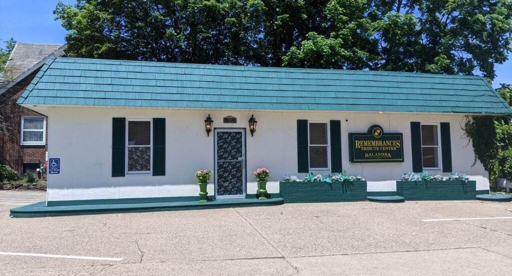 a white building with a green roof and a sign that says ' baker ' on it