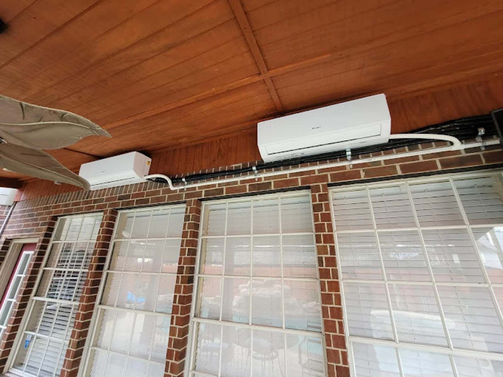 A ceiling fan is hanging from the ceiling of a brick building.