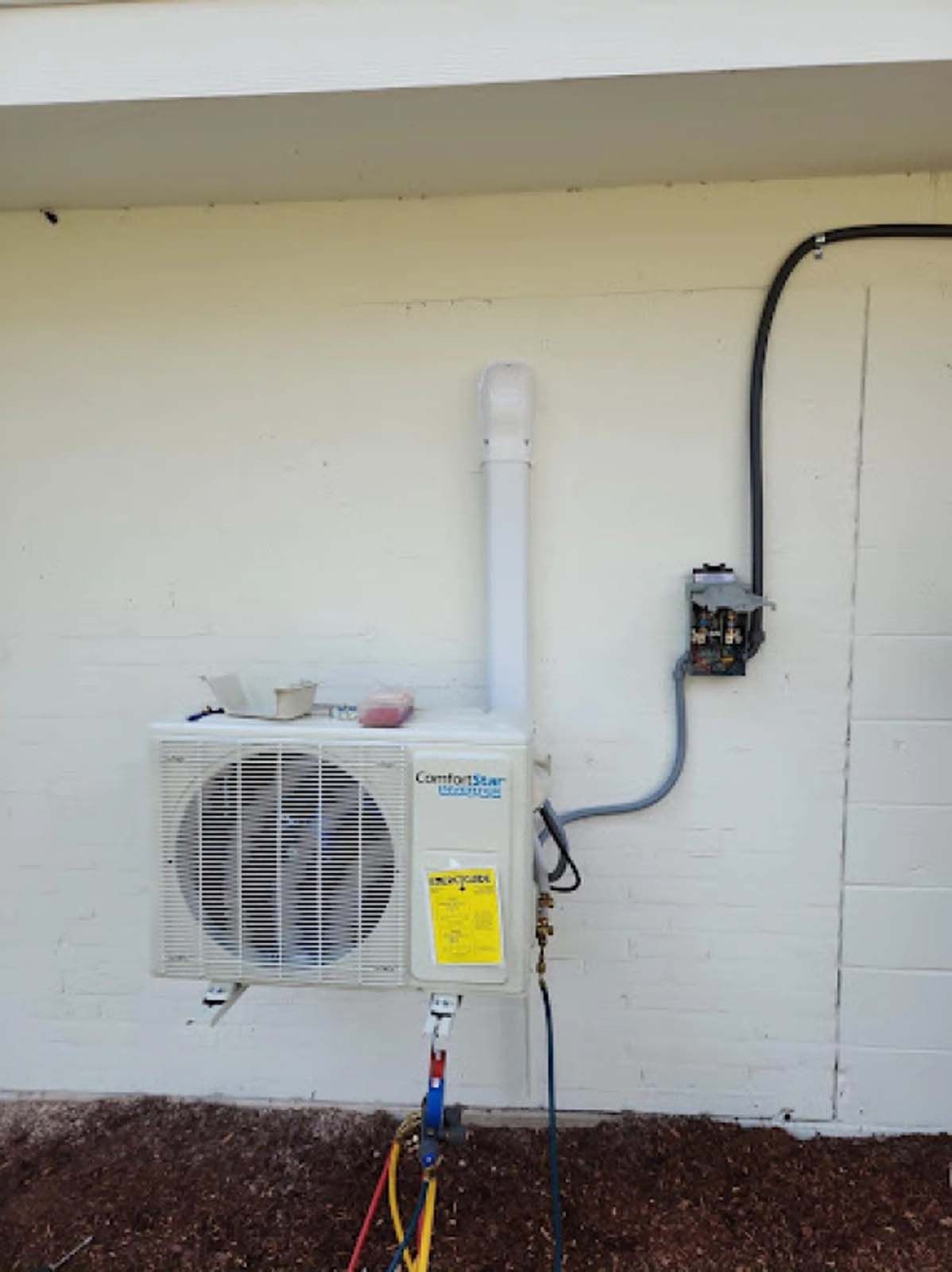 An air conditioner is mounted on the side of a building.