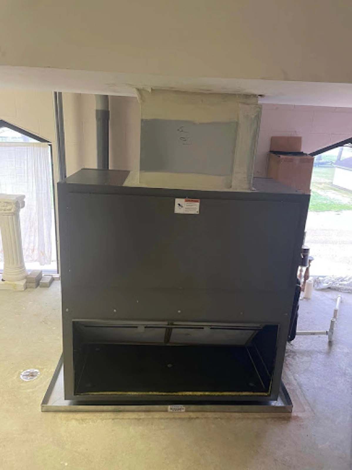 A large black box is sitting in a room next to a window.