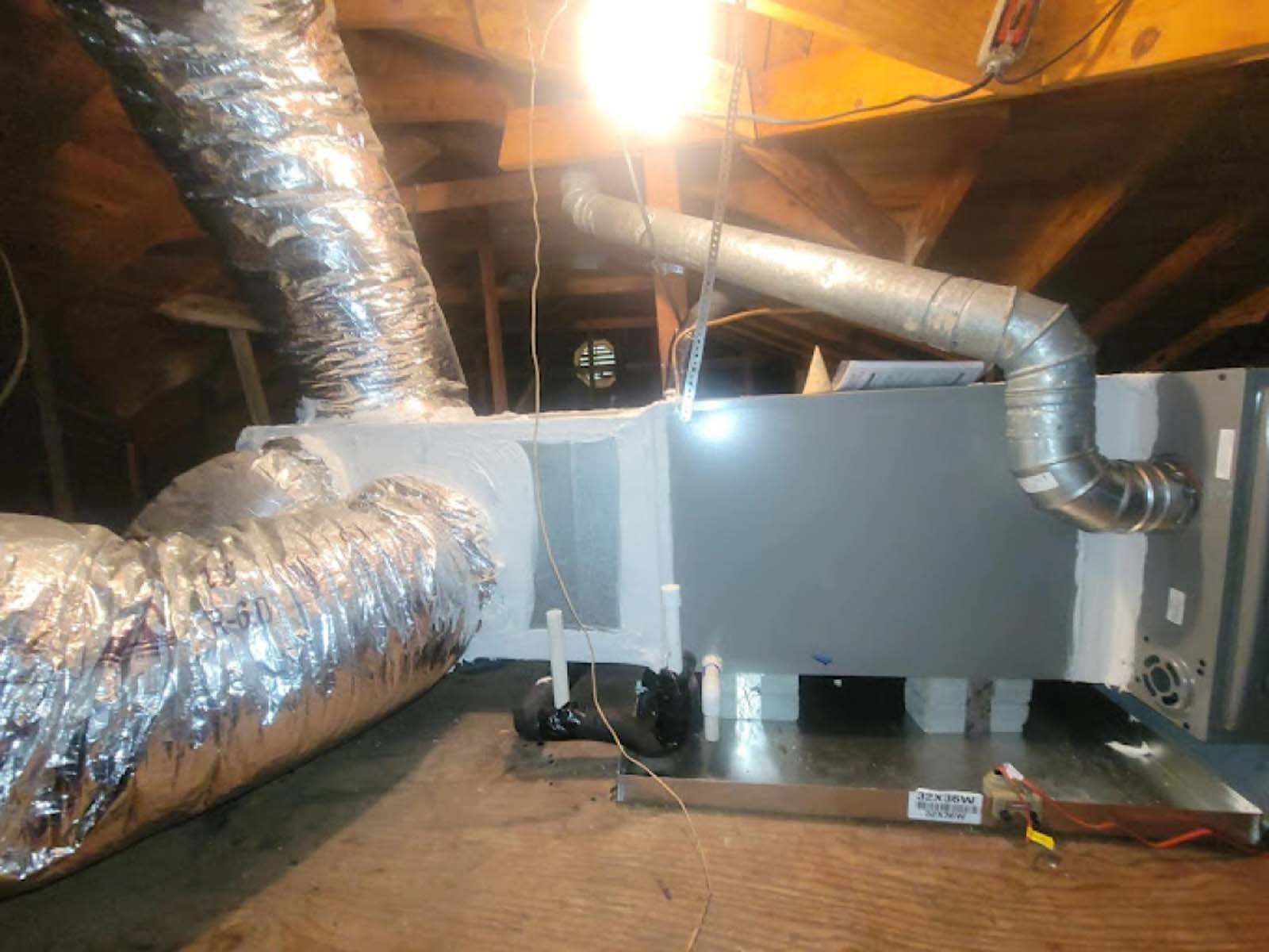 A ventilation system is being installed in an attic.