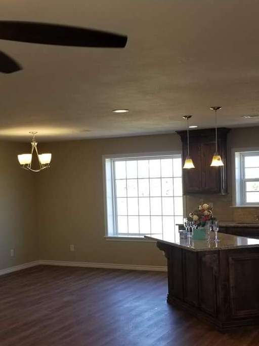 A kitchen with a large island and a ceiling fan.