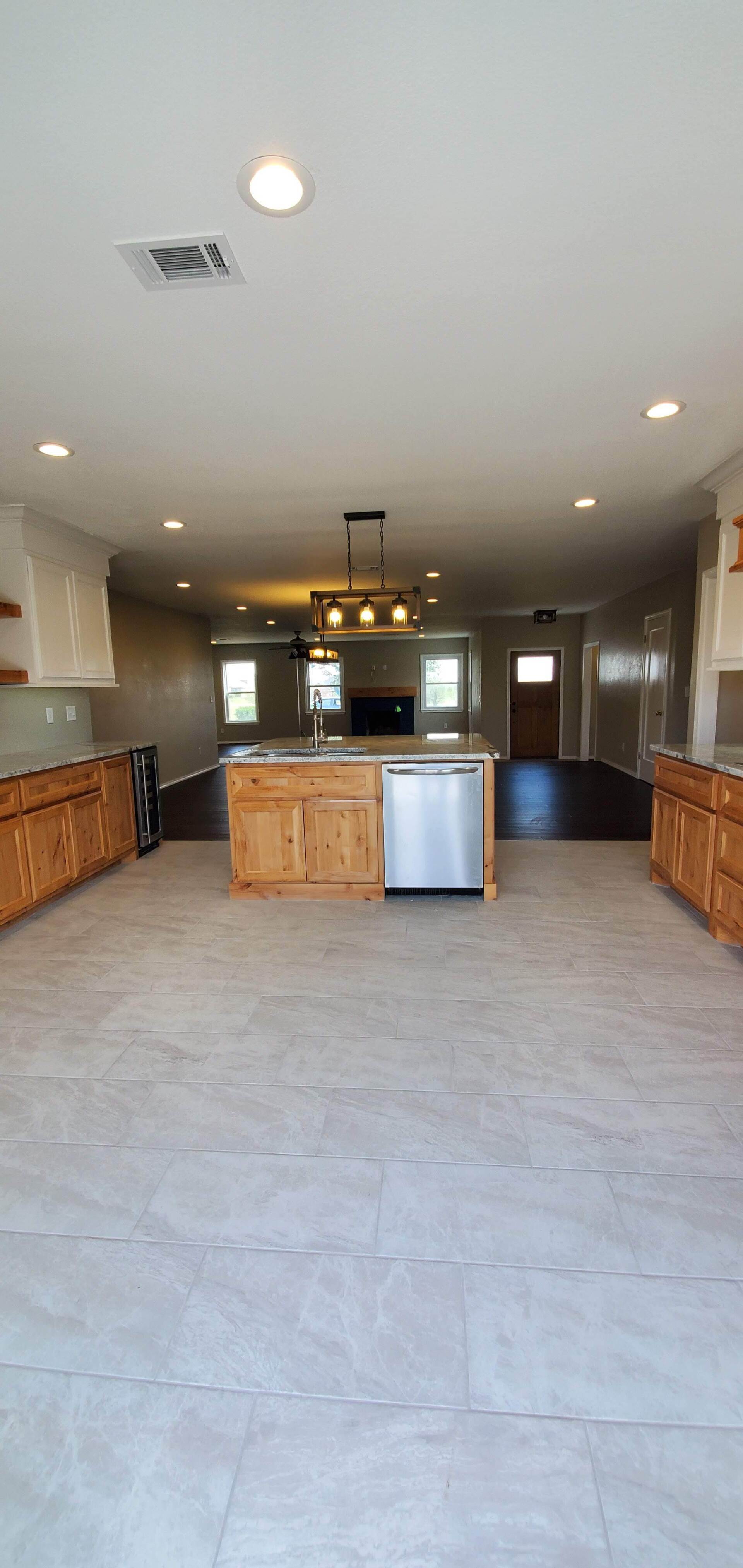 A large kitchen with a large island and stainless steel appliances.