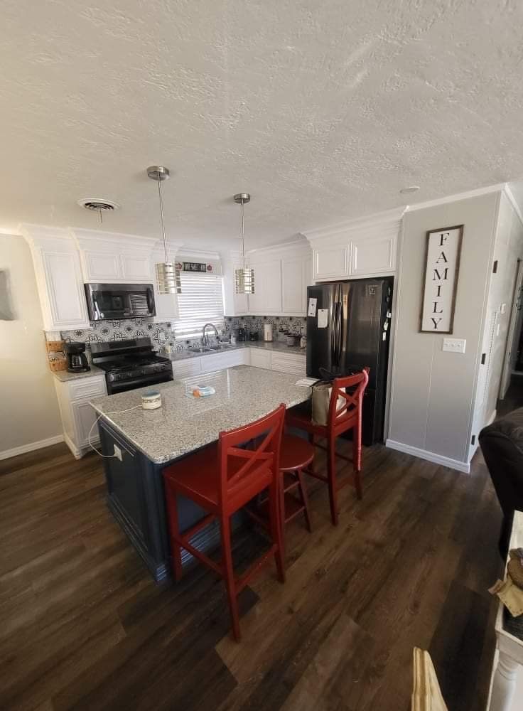 A kitchen with a large island and red chairs.