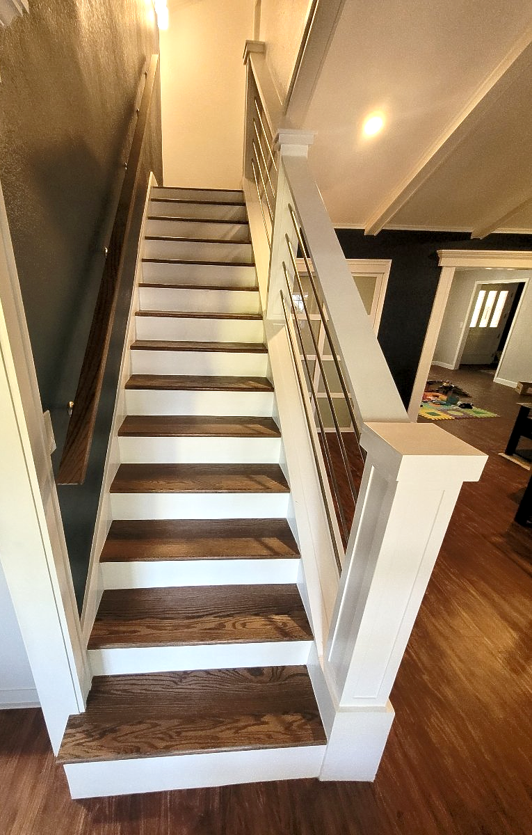 A staircase with wooden steps and a white railing in a house.