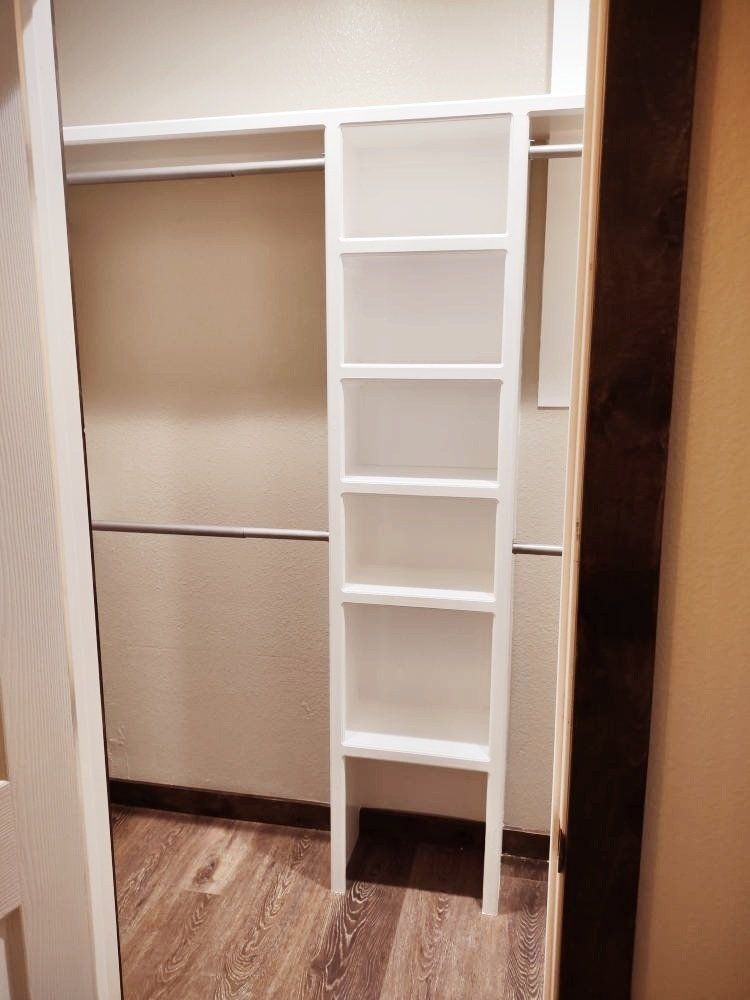 A walk in closet with a ladder and shelves