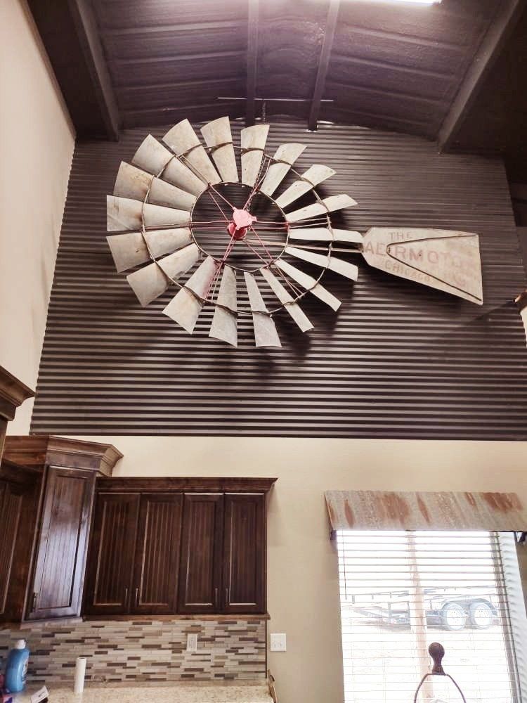 A large windmill is hanging from the ceiling of a kitchen.