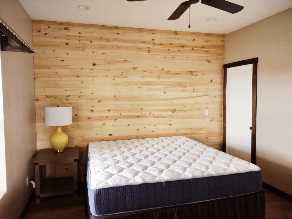 A bedroom with a mattress and a ceiling fan